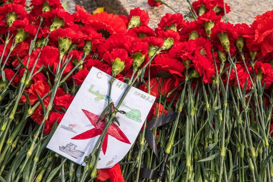 By midday, the monument is already buried in flowers