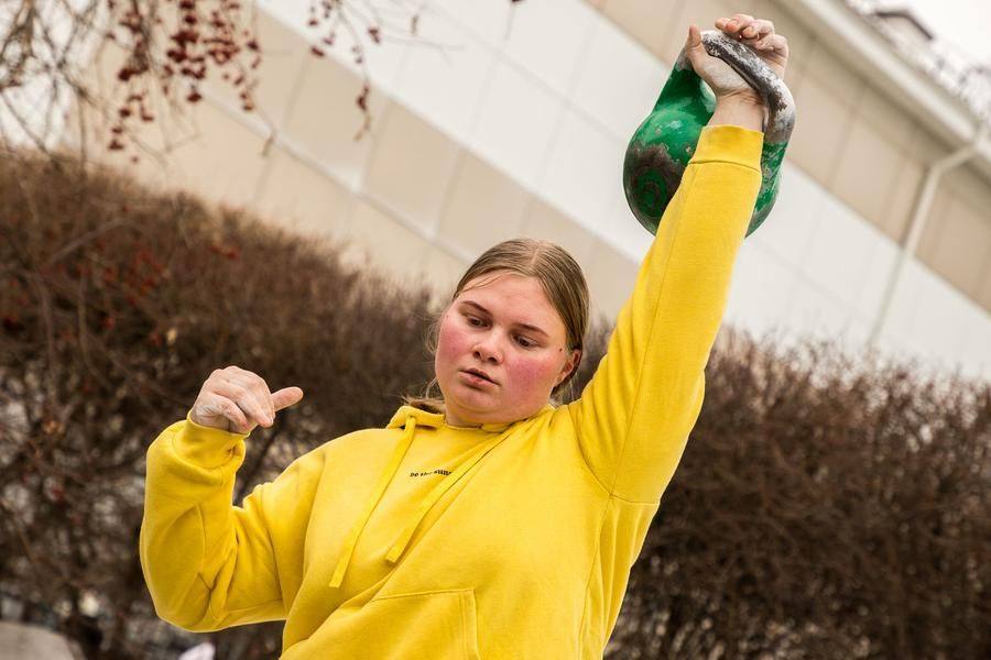 A young athlete from the sports club effortlessly lifts a 24‑kilogram kettlebell