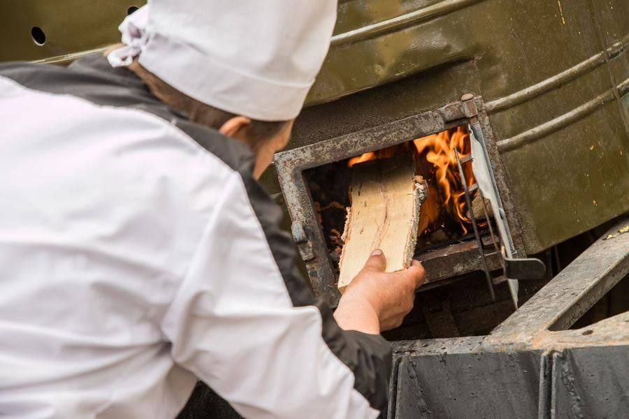 The cooks tend the fire in each field kitchen themselves