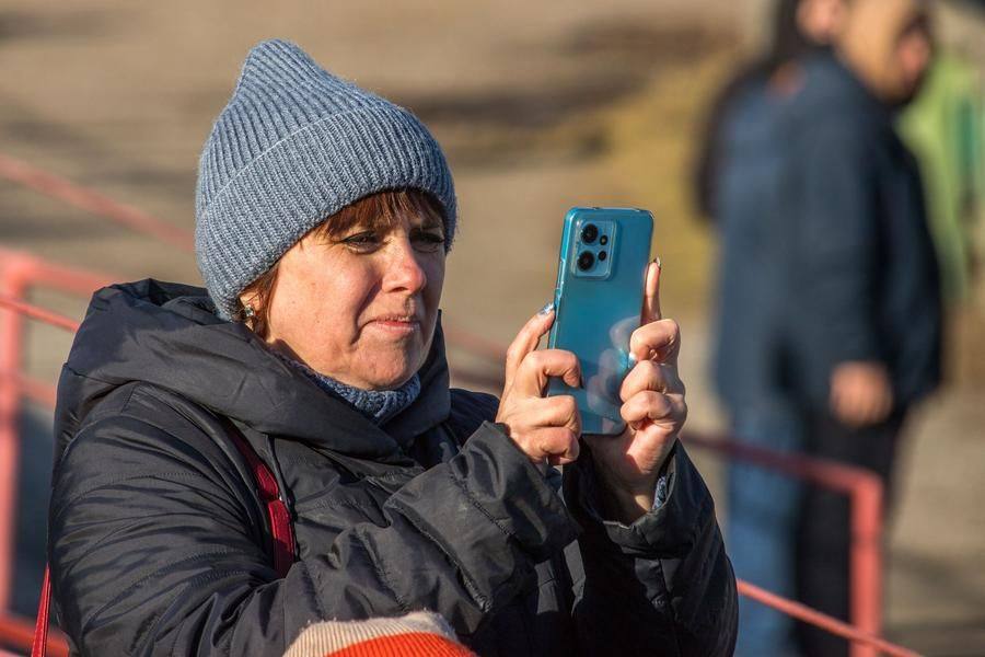 In the stands, spectators are eager to capture the race’s best moments