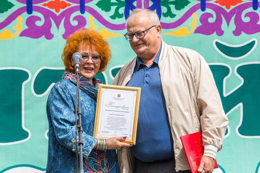 On stage are Natalya Stepanova, director of the Omsk House of Friendship, and Sergei Vysotsky, head of the district