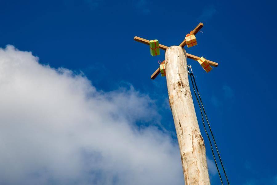 The daredevils face a pole so tall that climbing safety gear is provided