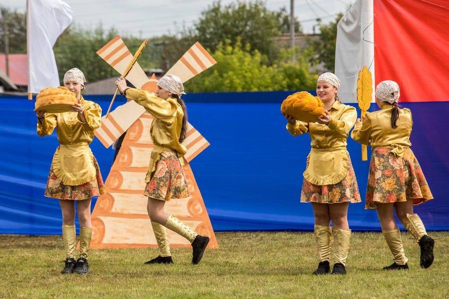 Blacksmiths, grain growers, and bakers appear on stage in stylized costumes, honoring all working people