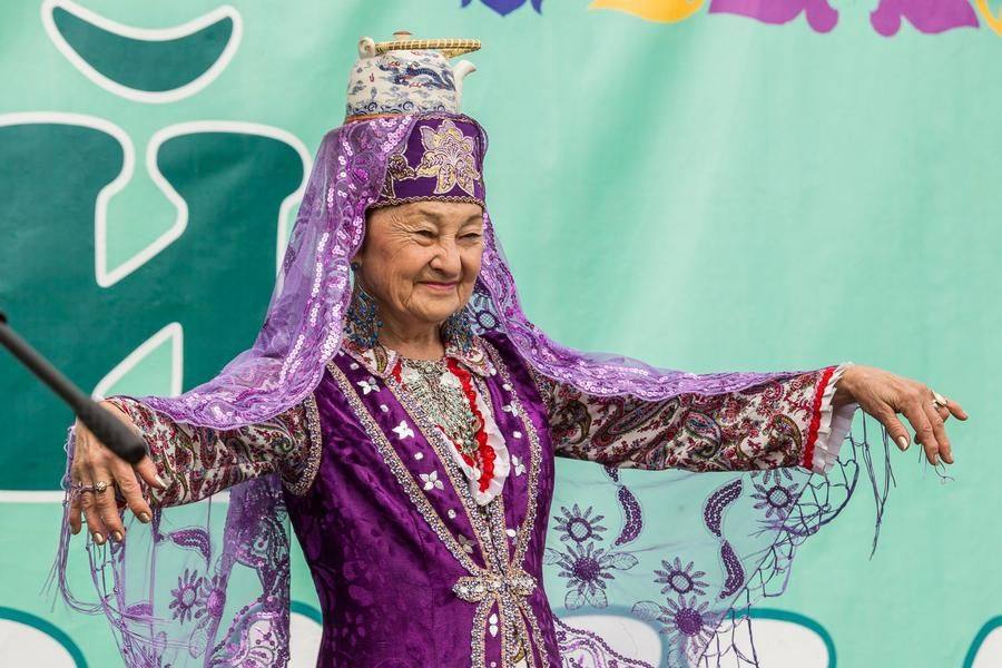 Nazakat Melkova performs a Tatar dance with a samovar‑style teapot