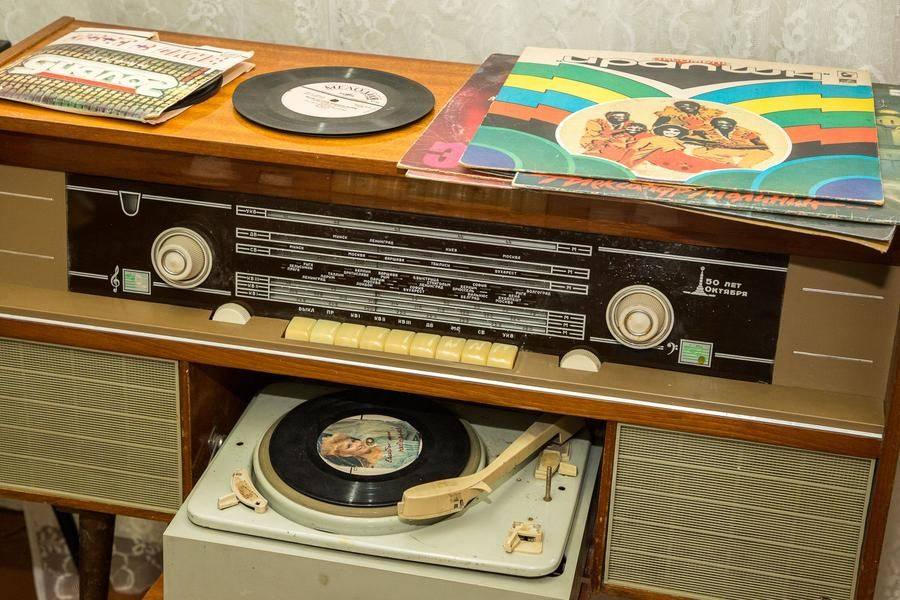 A retro radio‑and‑record player and trendy records show the cultural tastes of the owners