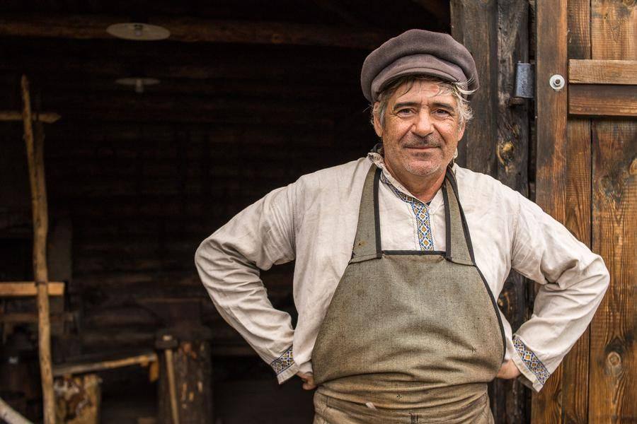 At the forge gates, a blacksmith greets the guests