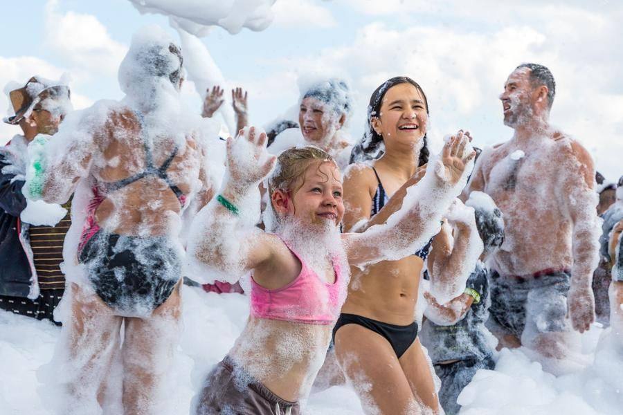 Kids are probably the stars of this foam party — but definitely not the only ones