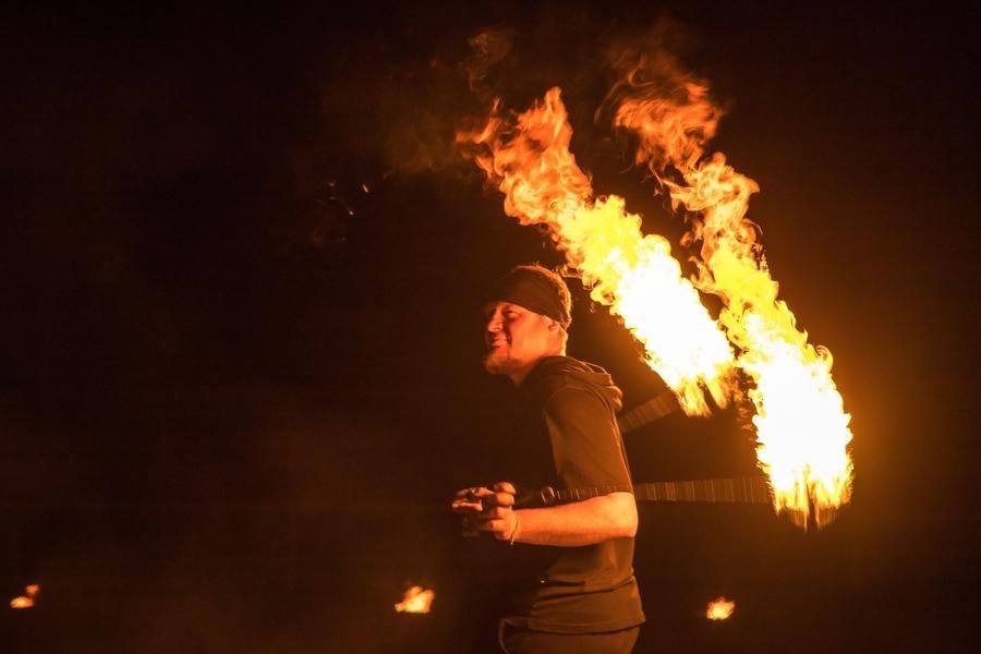 The artist stays calm and fully controls the high‑speed rotation of the burning balls