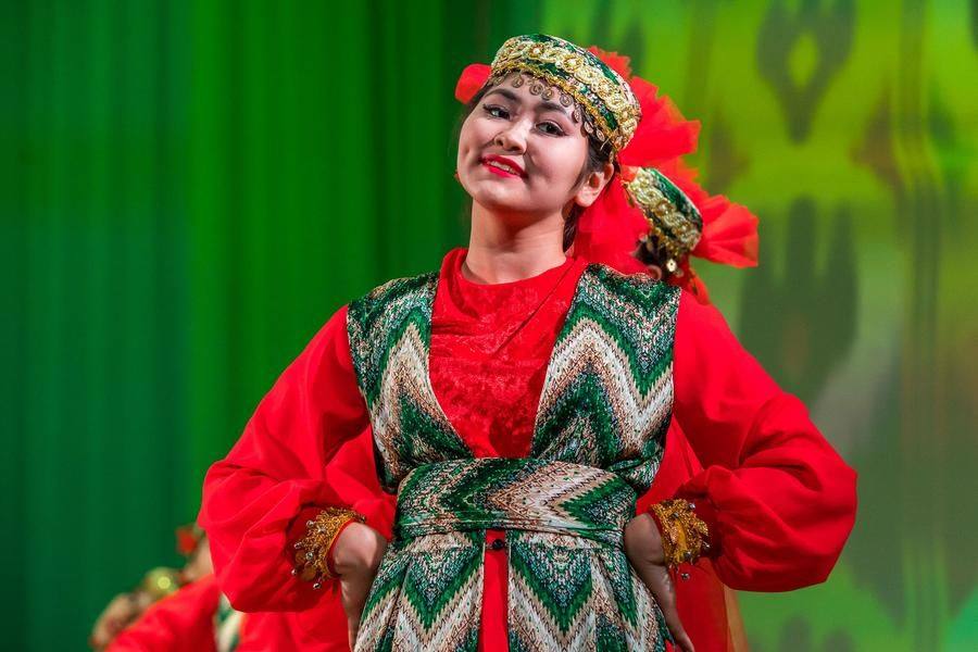 The dancers’ costumes stand out with contrasting patterns and vibrant decor
