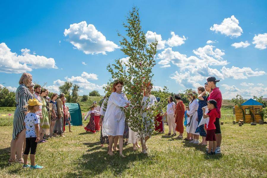 Festival participants form an arrow‑shaped ring dance