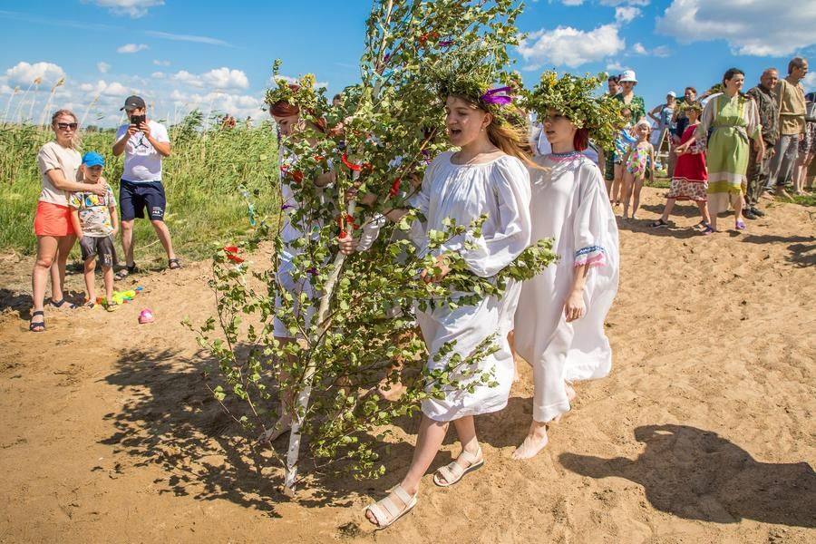 The procession approaches the water’s edge, where a crowd of curious onlookers has already gathered