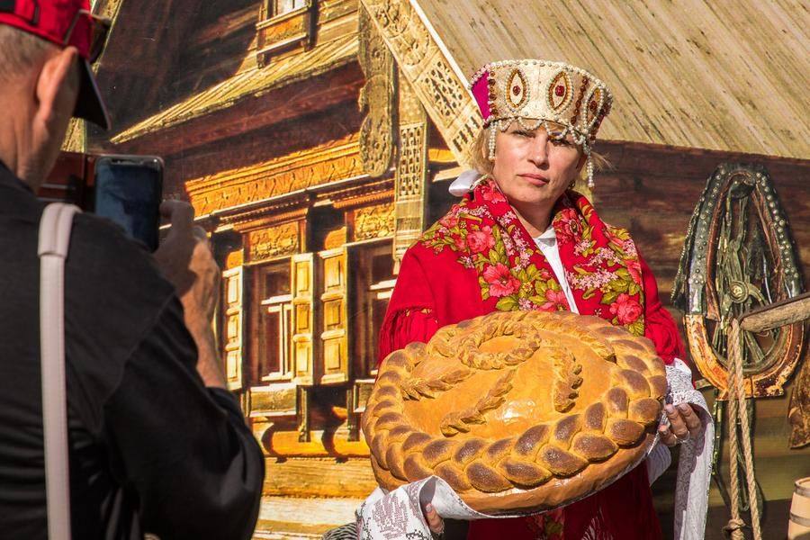 Visitors can take a photo in a folk costume against the backdrop of a neatly kept traditional house
