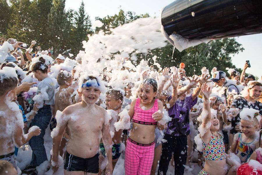 Dozens of people try to catch the foam cannon operator’s attention