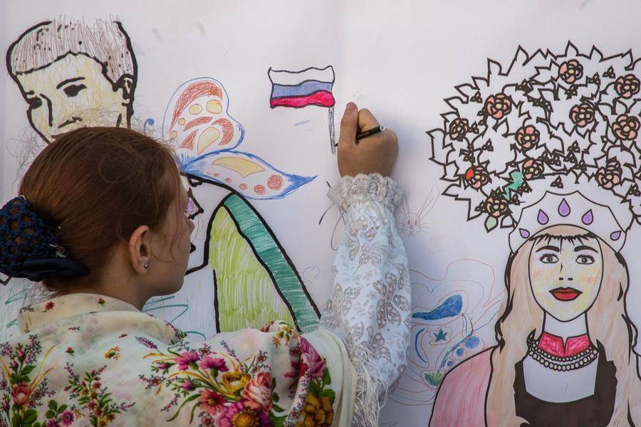 While they wait for their turn, the young artists color in outline panels and add the missing details