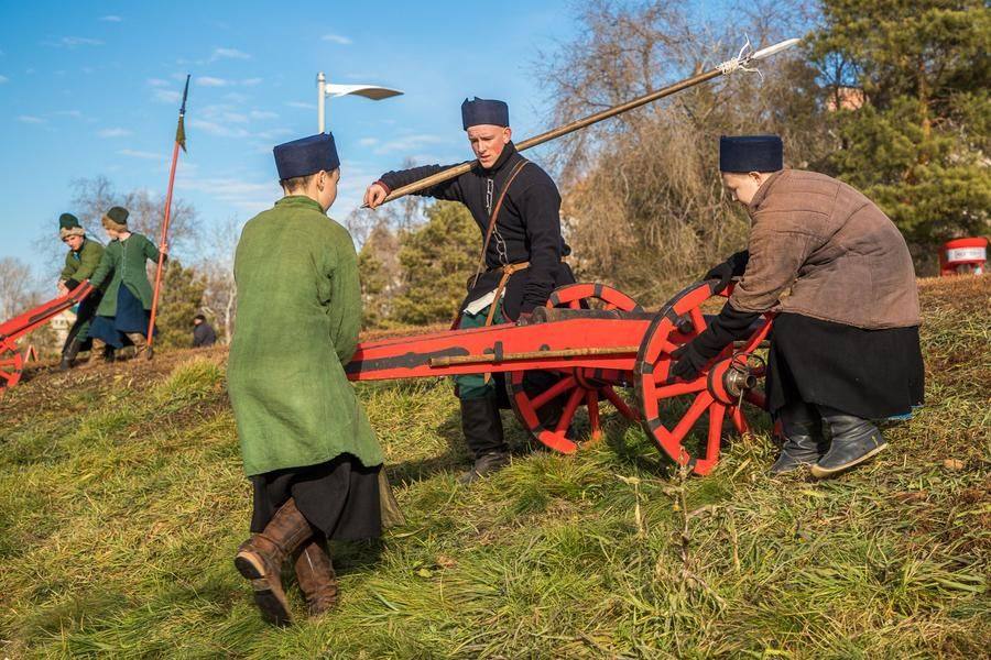 Heavy cannons are carefully lowered down the slope to the water