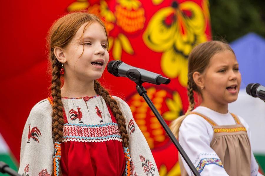The stage stays alive with performances — both young artists and seasoned folk‑song singers bring their talent to the