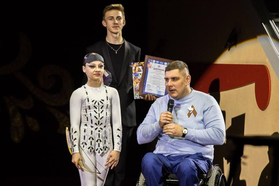 The Grand Prix is presented to her by Alexander Kuzyukov from Omsk — a Paralympic fencing champion